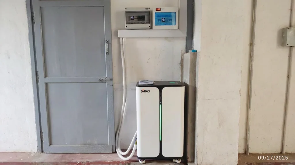 SAKO all-in-one energy storage system installed indoors, connected to wall meters, next to a closed grey door.