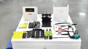 SAKO ESS 5-in-1 components with tools including inverter, circuit board, drill, and assembly hardware on a workshop table.